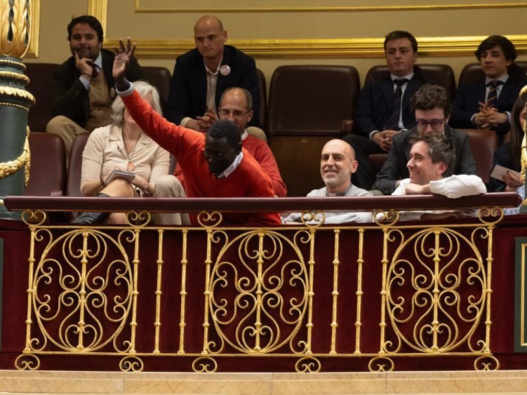 Augustin Ndour, primer firmante de la ILP de Regularización Extraordinaria, saluda desde la tribuna del Congreso de los Diputados tras la aprobación de la Toma en Consideración el 9 de abril de 2024